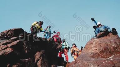 登山者的陪伴站在山顶上，高兴而微笑地举起双手。 操作员移除
